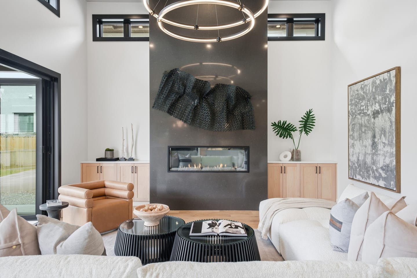 Great room with full-height charcoal fireplace wall and white oak floors