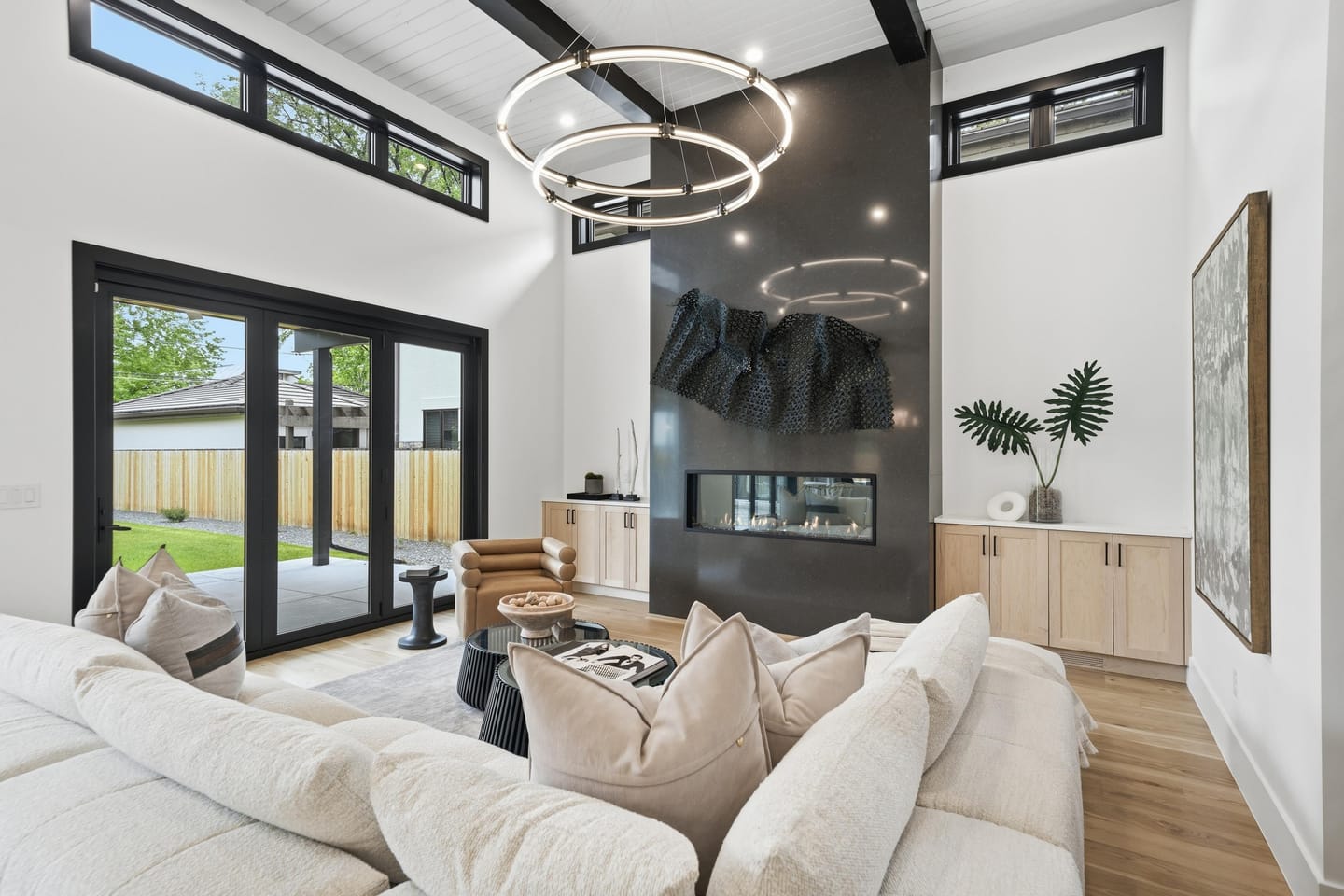 Great room with full-height charcoal fireplace wall and white oak floors