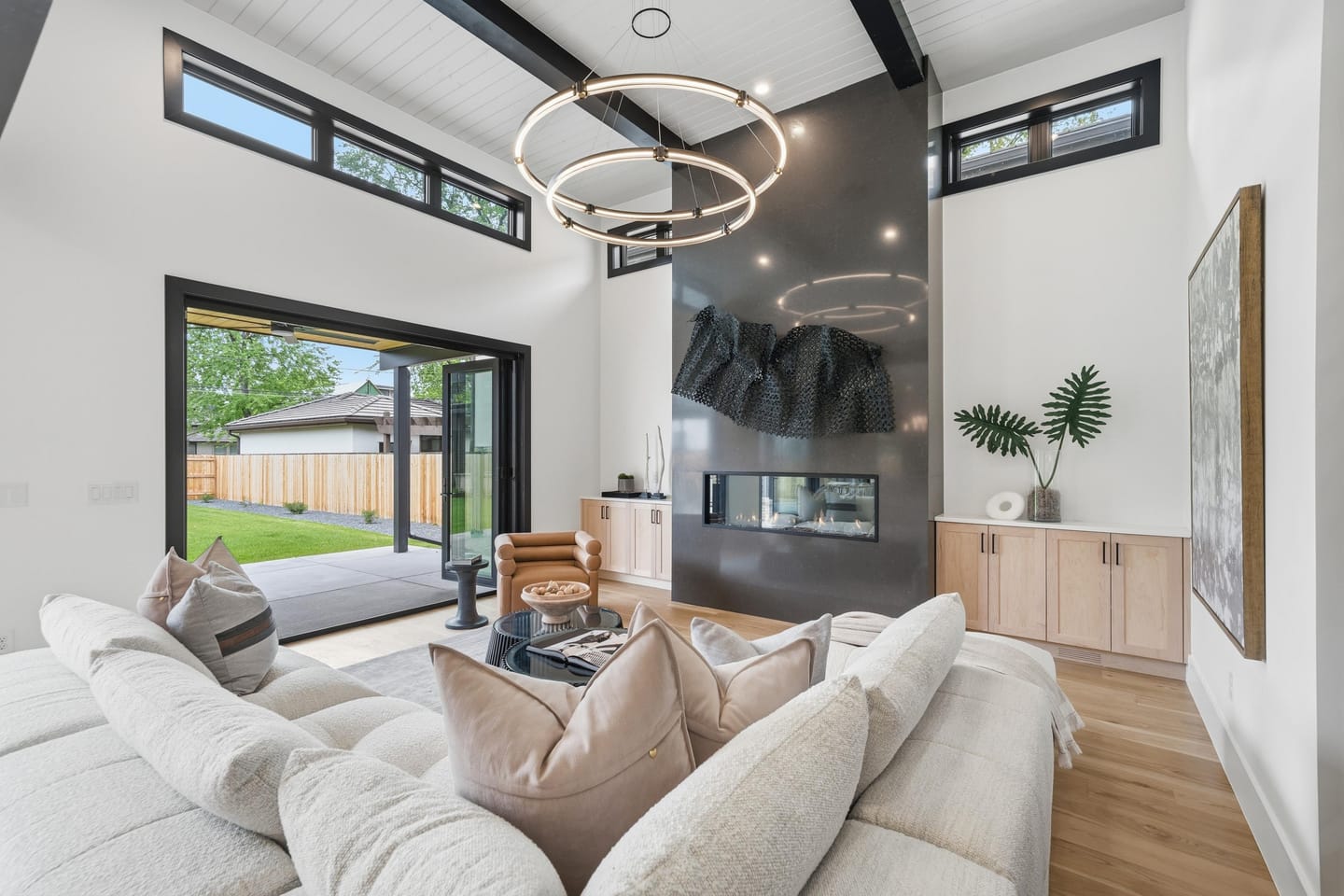 Great room with full-height charcoal fireplace wall and white oak floors