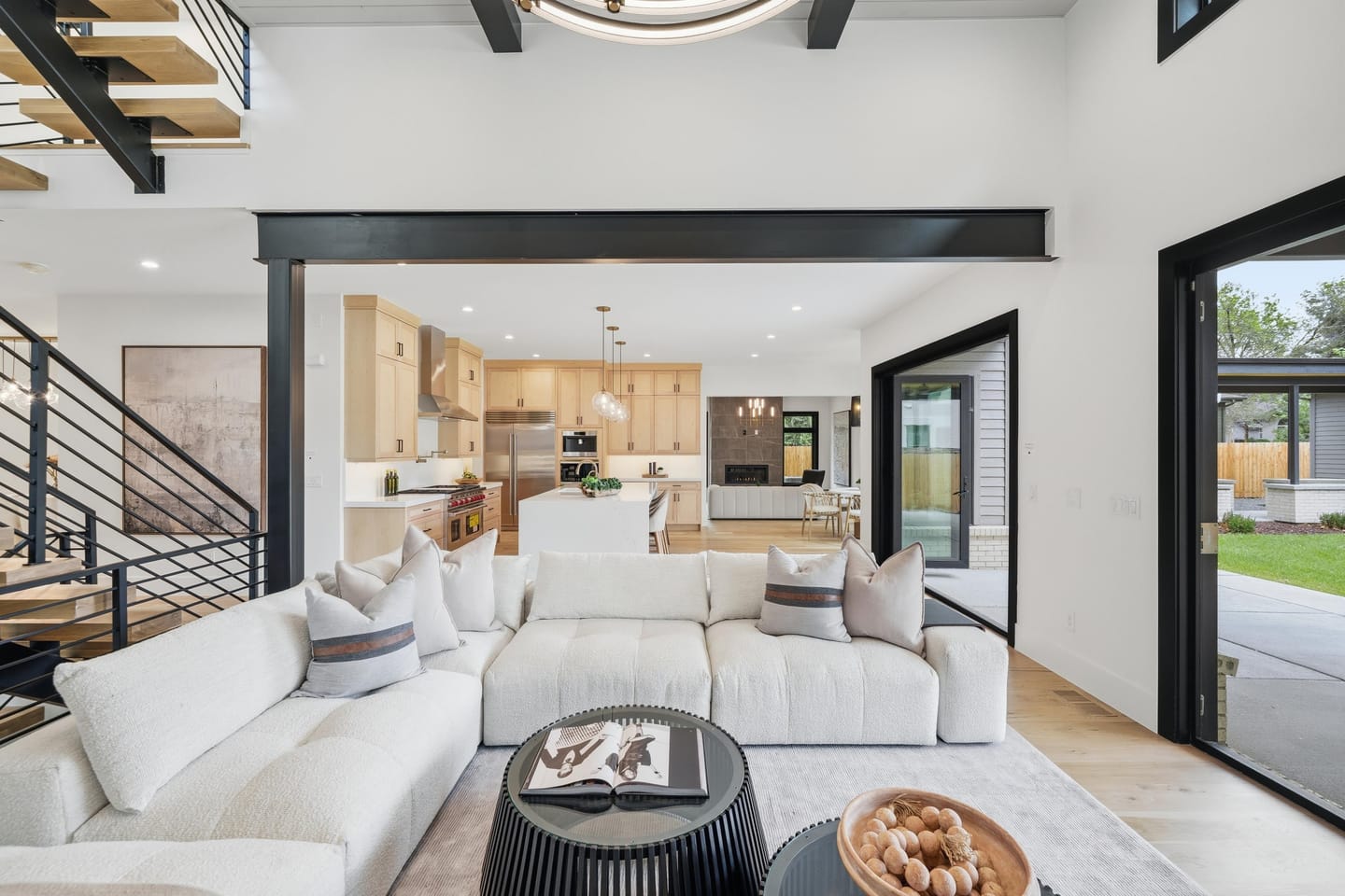 Great room with full-height charcoal fireplace wall and white oak floors