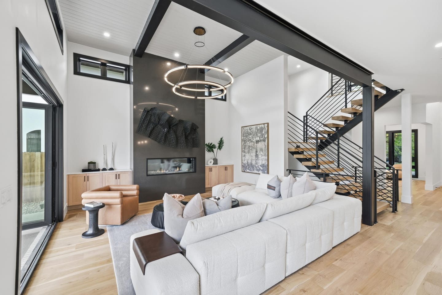 Great room with full-height charcoal fireplace wall and white oak floors