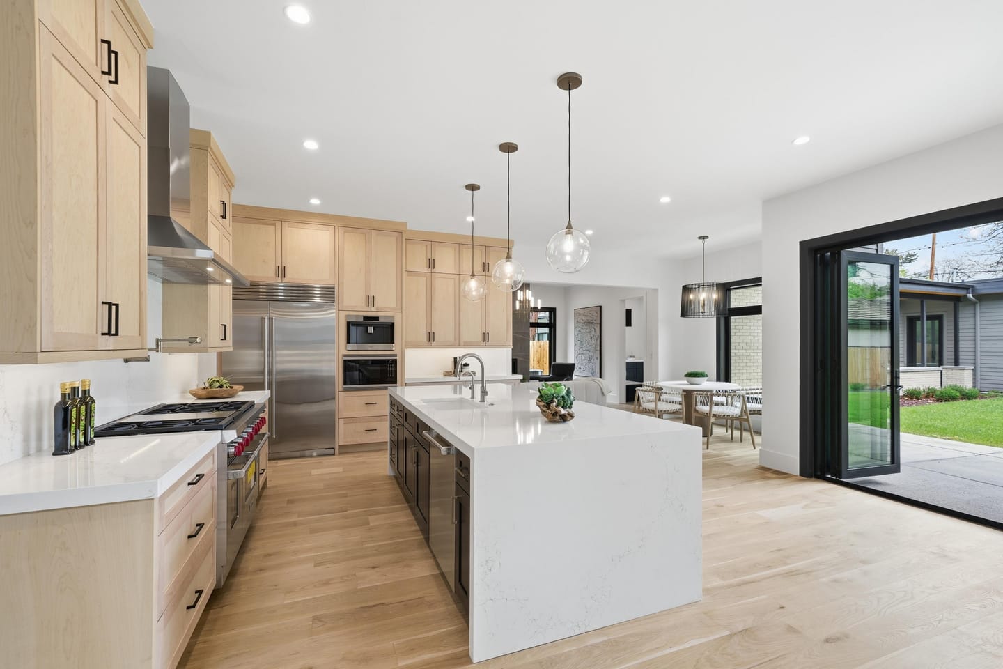 Chef kitchen with white oak cabinetry, quartz island and Wolf range