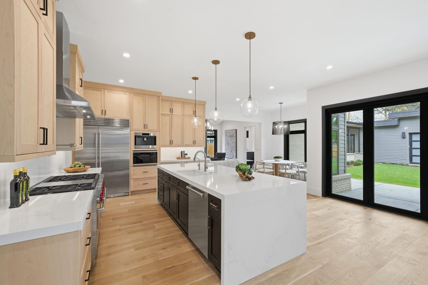 Chef kitchen with white oak cabinetry, quartz island and Wolf range