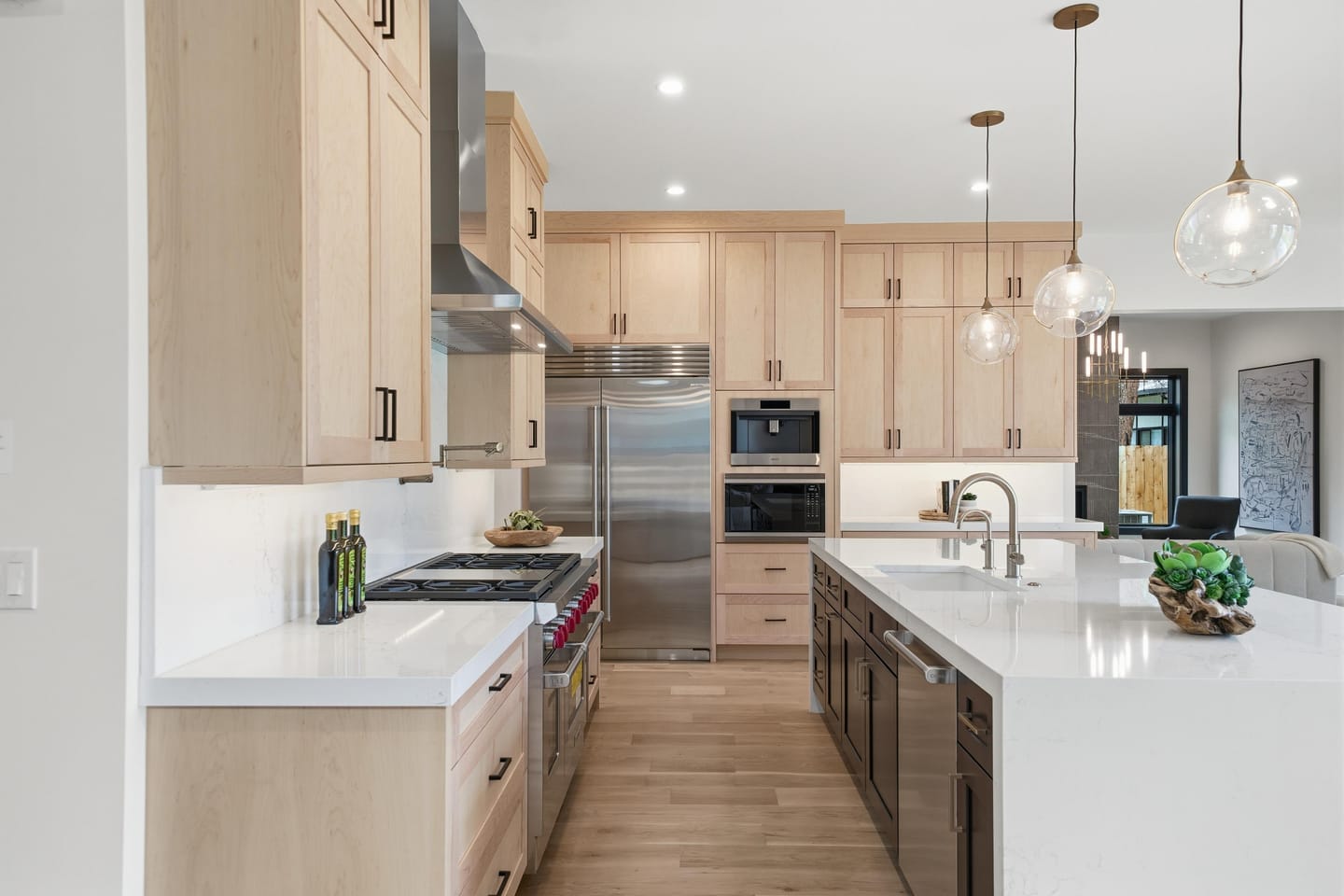 Chef kitchen with white oak cabinetry, quartz island and Wolf range
