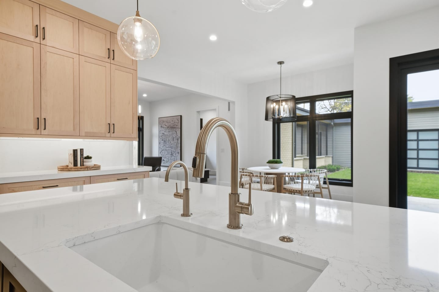 Chef kitchen with white oak cabinetry, quartz island and Wolf range