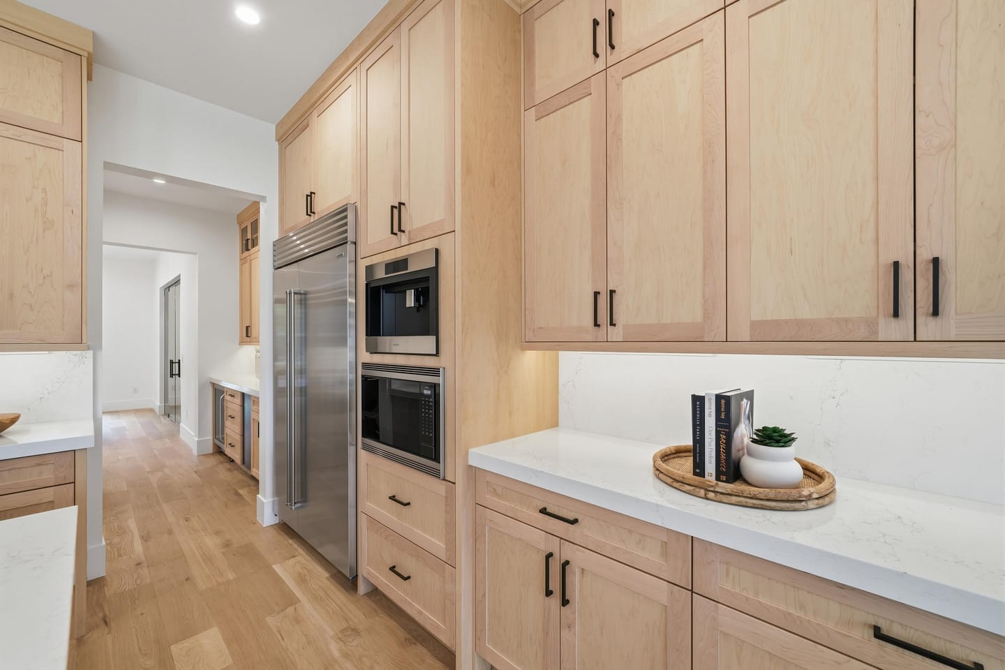 Chef kitchen with white oak cabinetry, quartz island and Wolf range