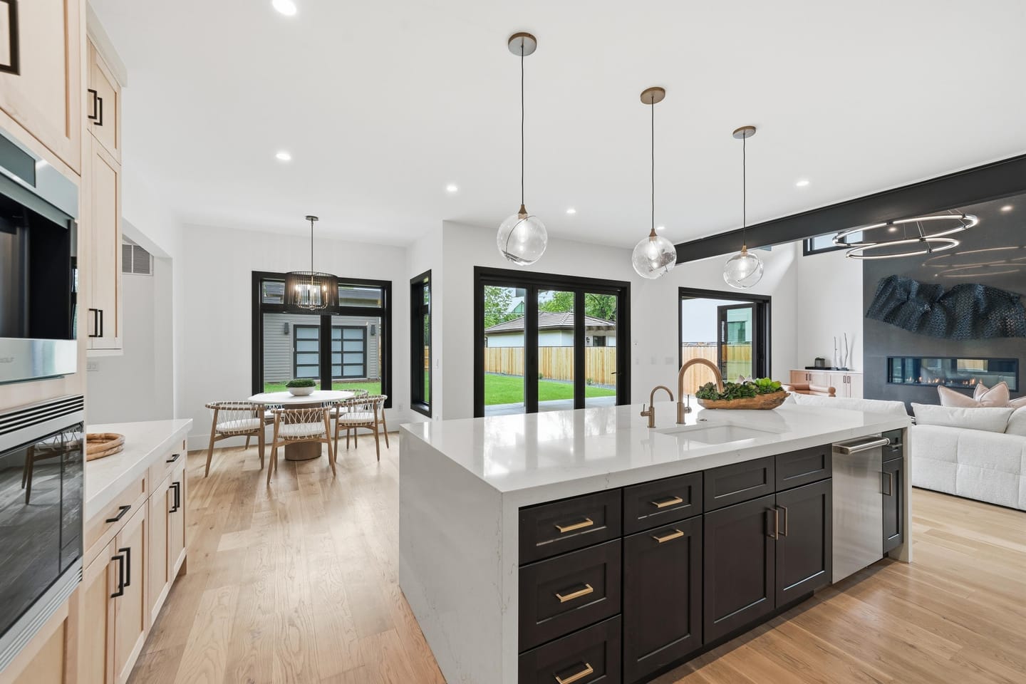 Chef kitchen with white oak cabinetry, quartz island and Wolf range