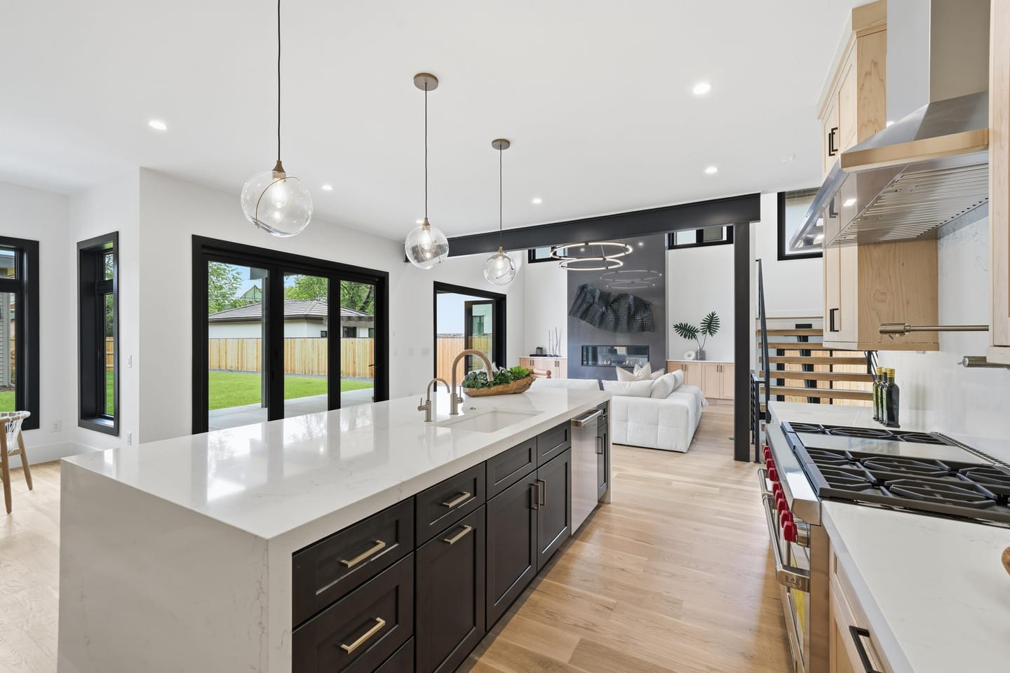 Chef kitchen with white oak cabinetry, quartz island and Wolf range