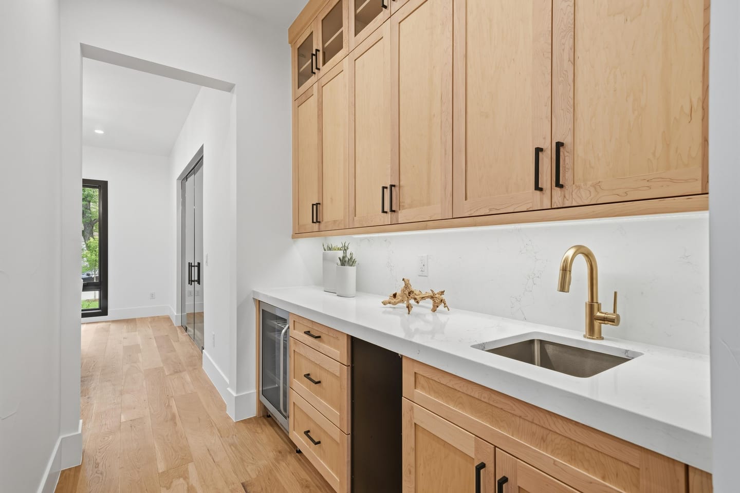Butler's pantry with quartz counter and brass fixtures