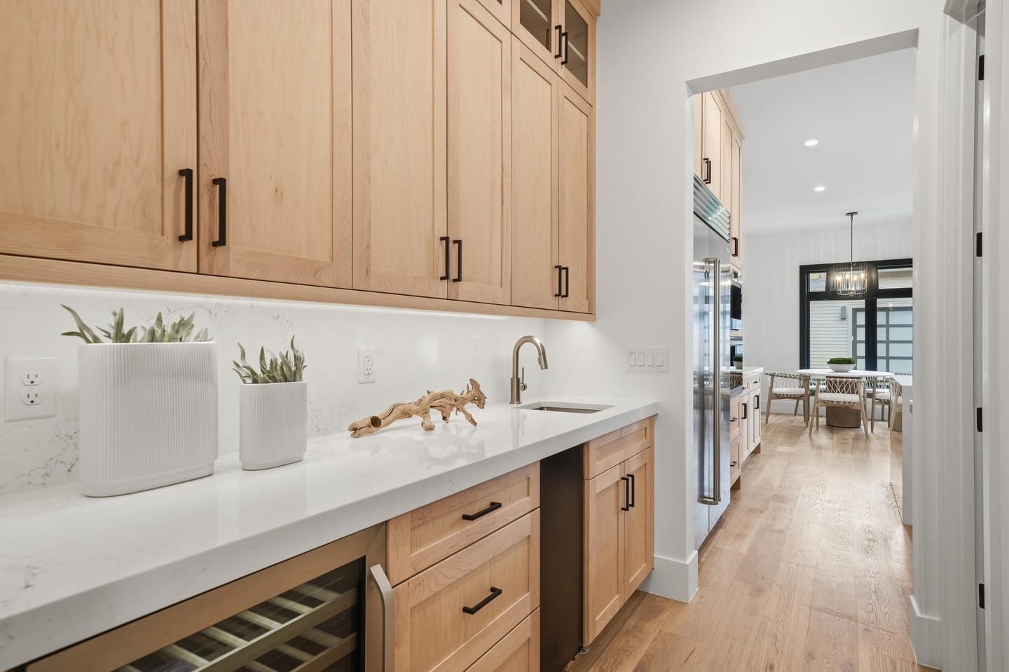 Walk-in pantry with dark cabinetry, sink and quartz counters