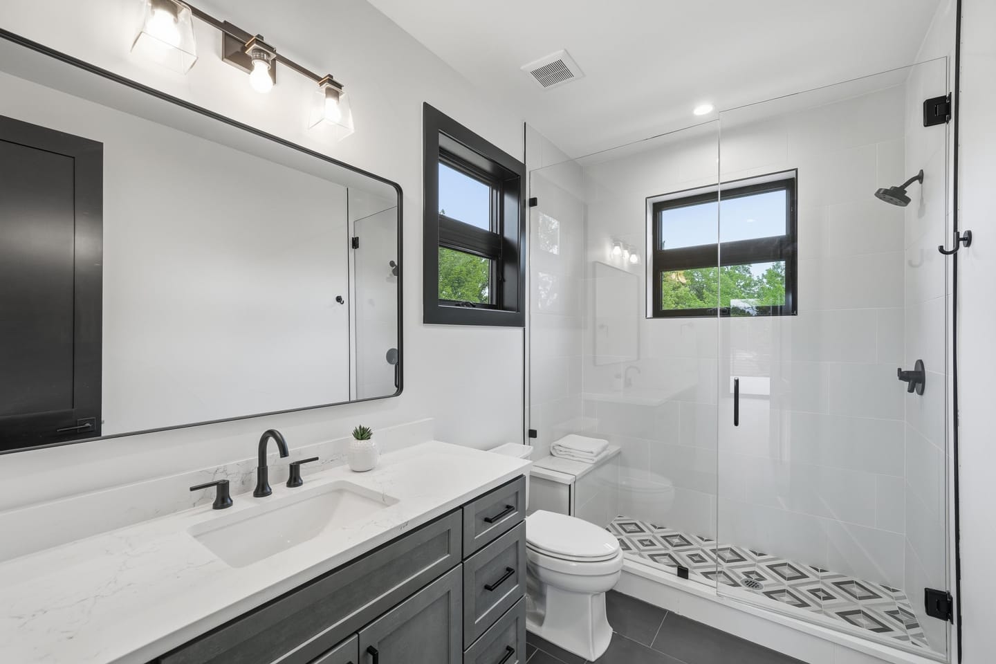 Bathroom with dark vanity and patterned floor tile
