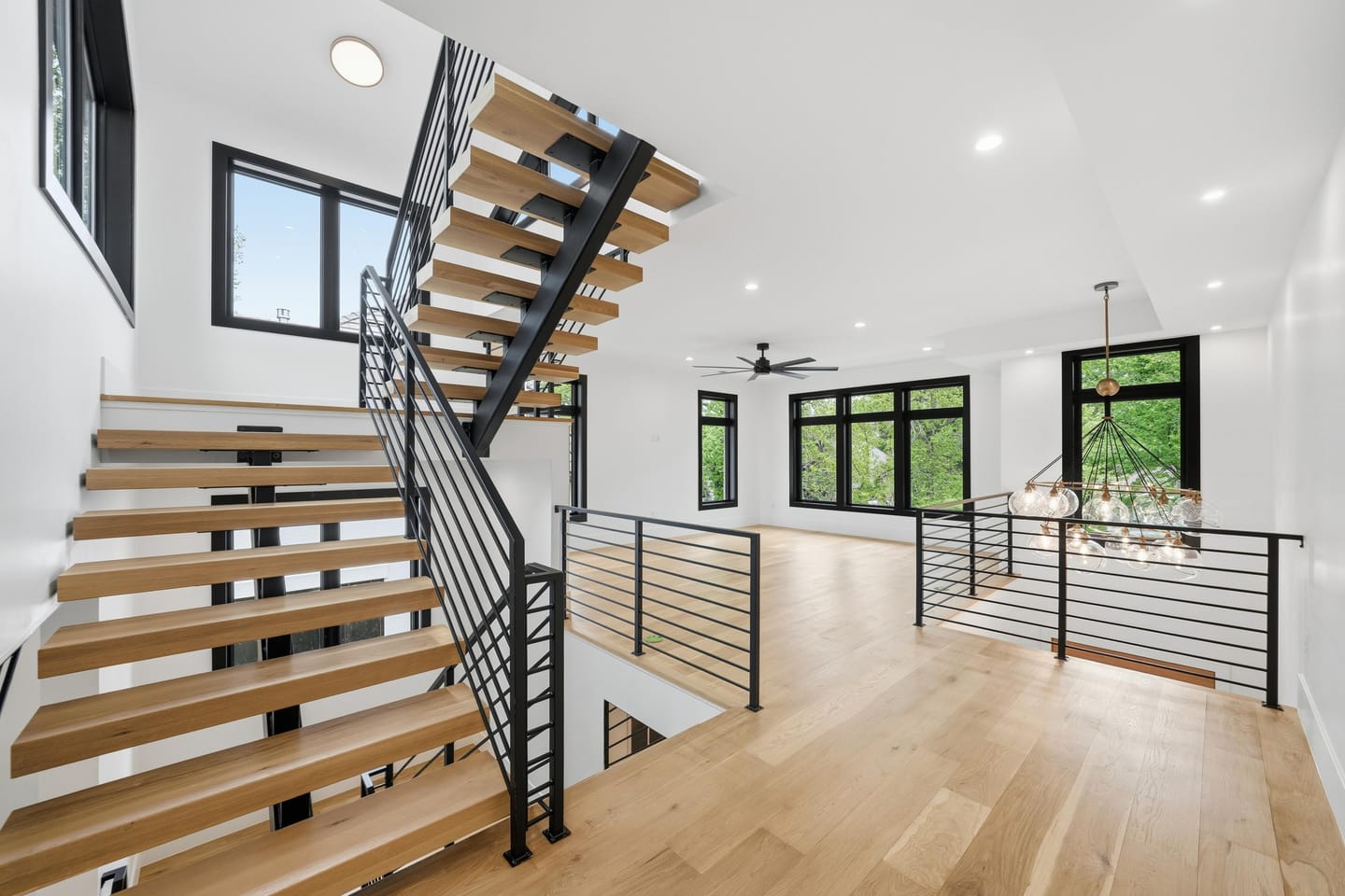 Floating white oak stair with blackened steel and cable railing