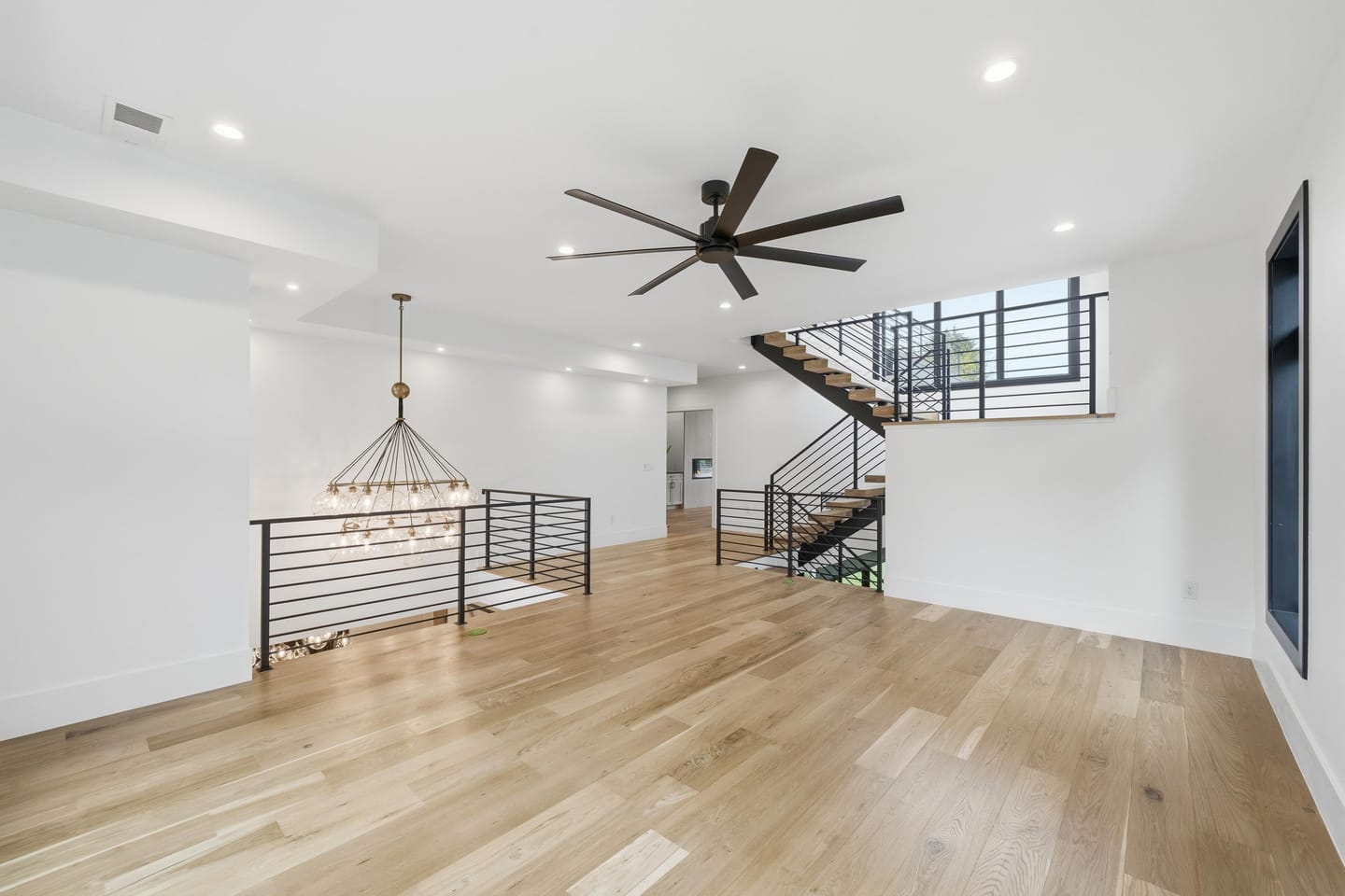 Floating white oak stair with blackened steel and cable railing