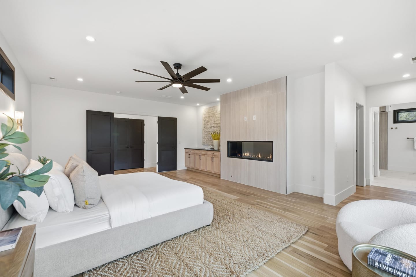 Primary suite with linear fireplace and black-framed glazing
