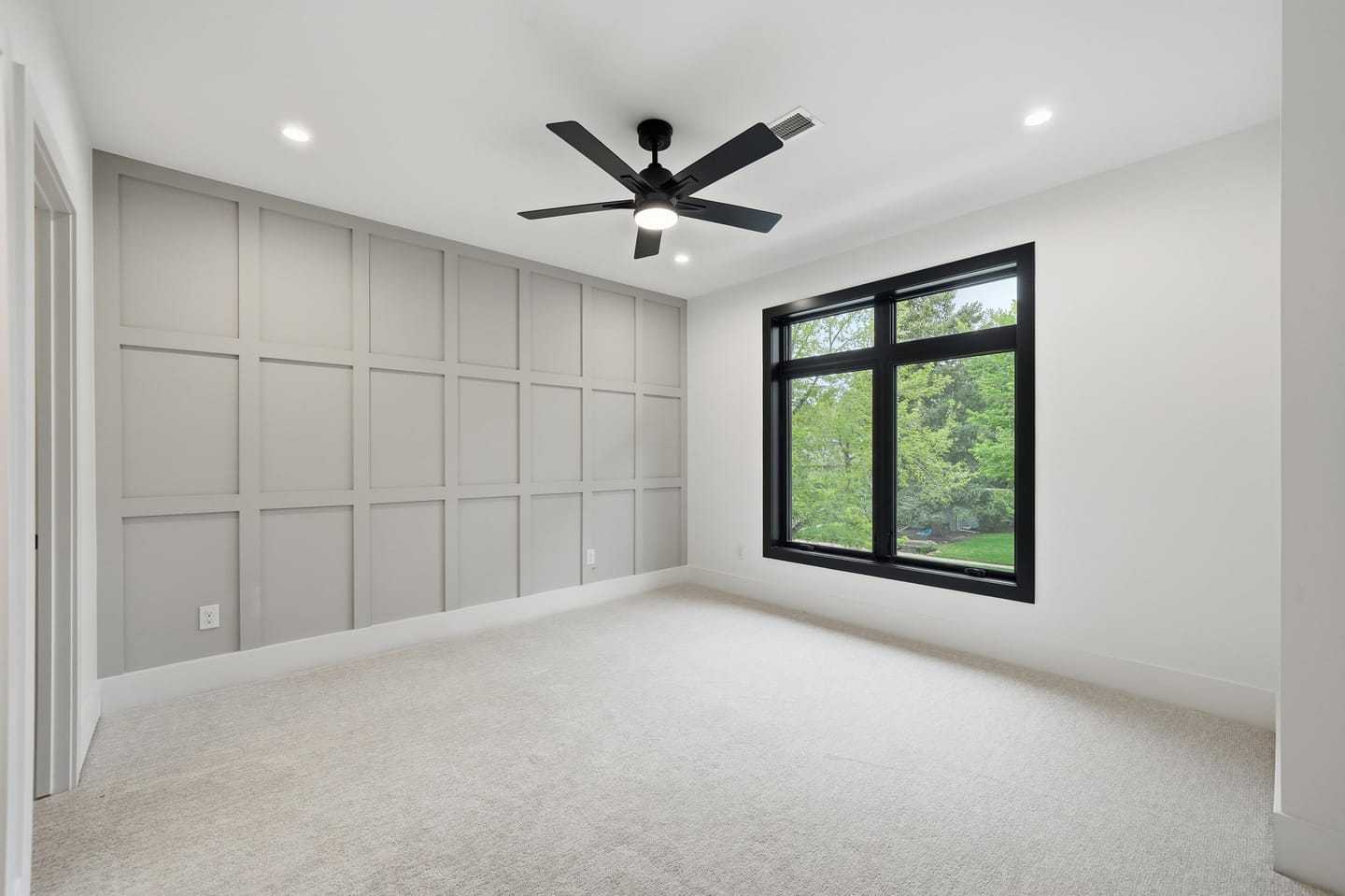 Secondary bedroom with panel-detail accent wall