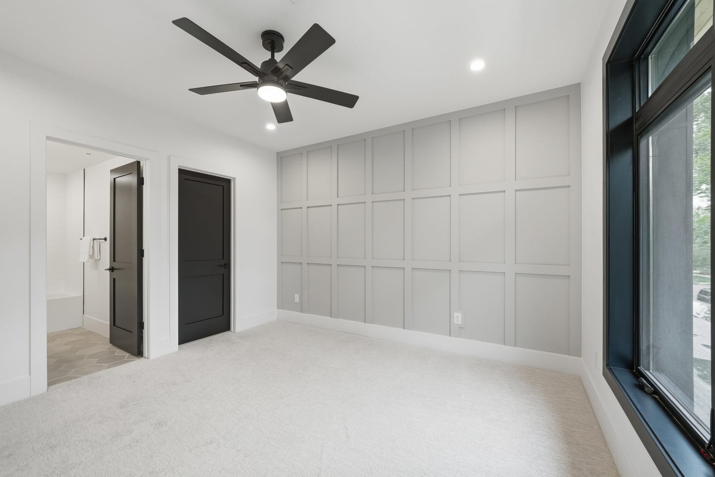 Secondary bedroom with panel-detail accent wall