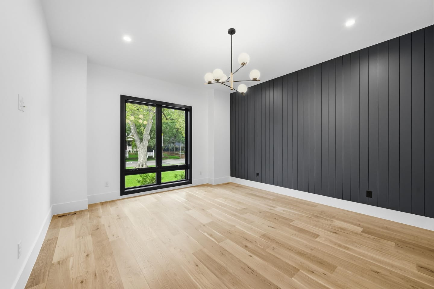 Room with charcoal vertical shiplap wall and white oak floors