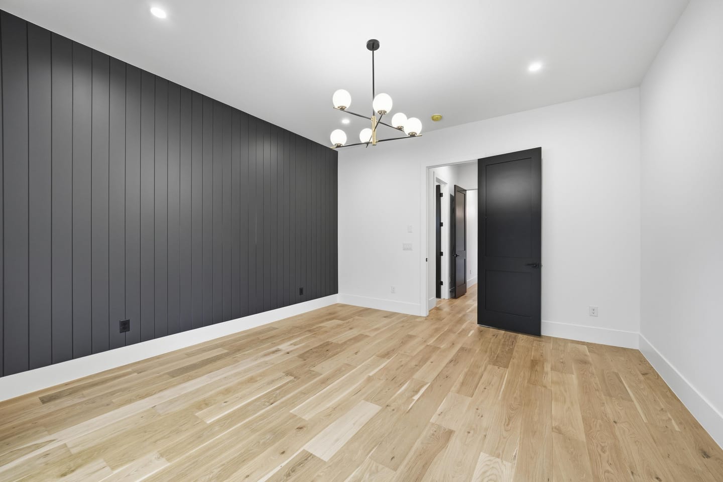 Room with charcoal vertical shiplap wall and white oak floors