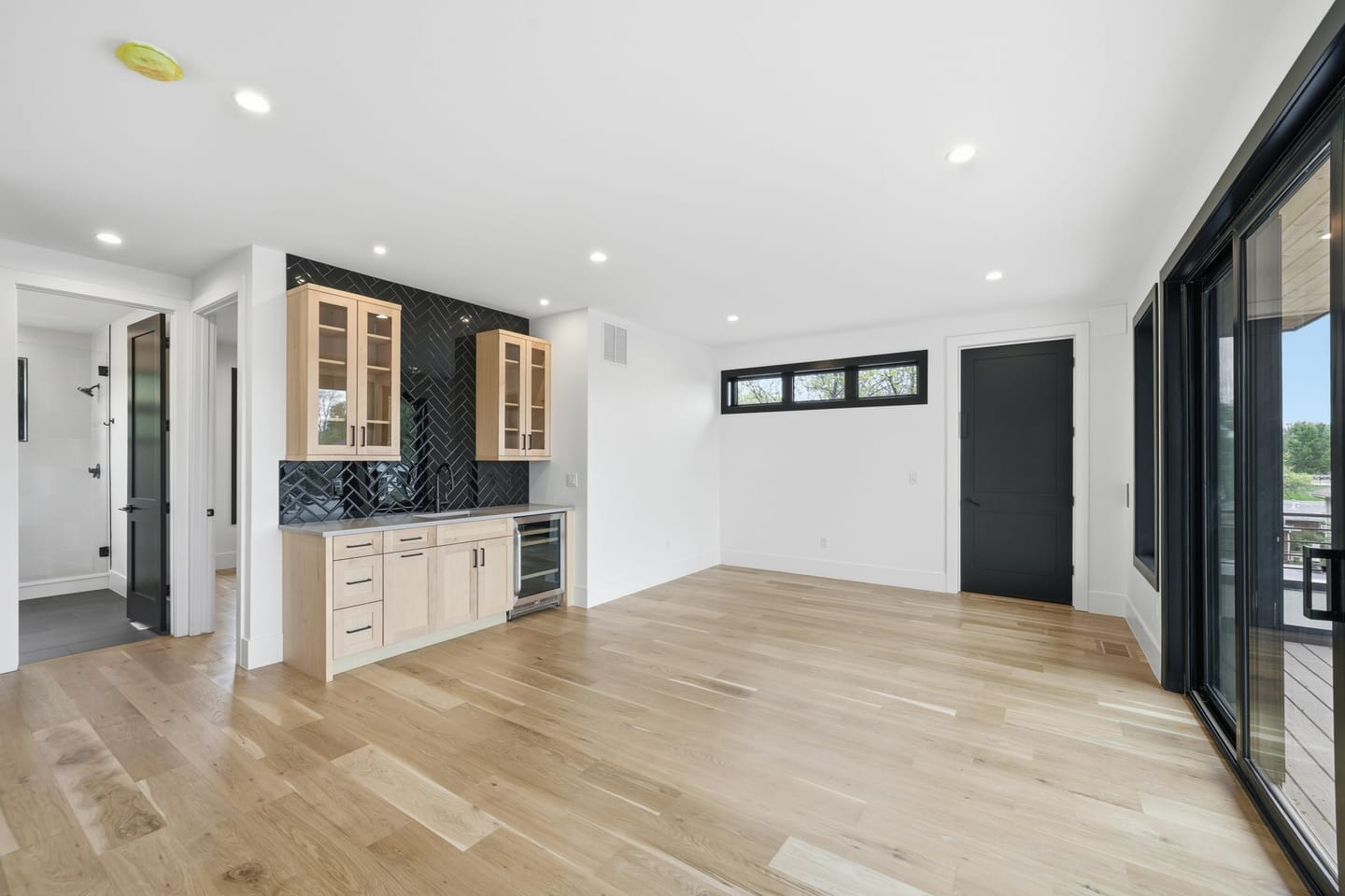 Upper-level lounge with wet bar opening to the rooftop deck
