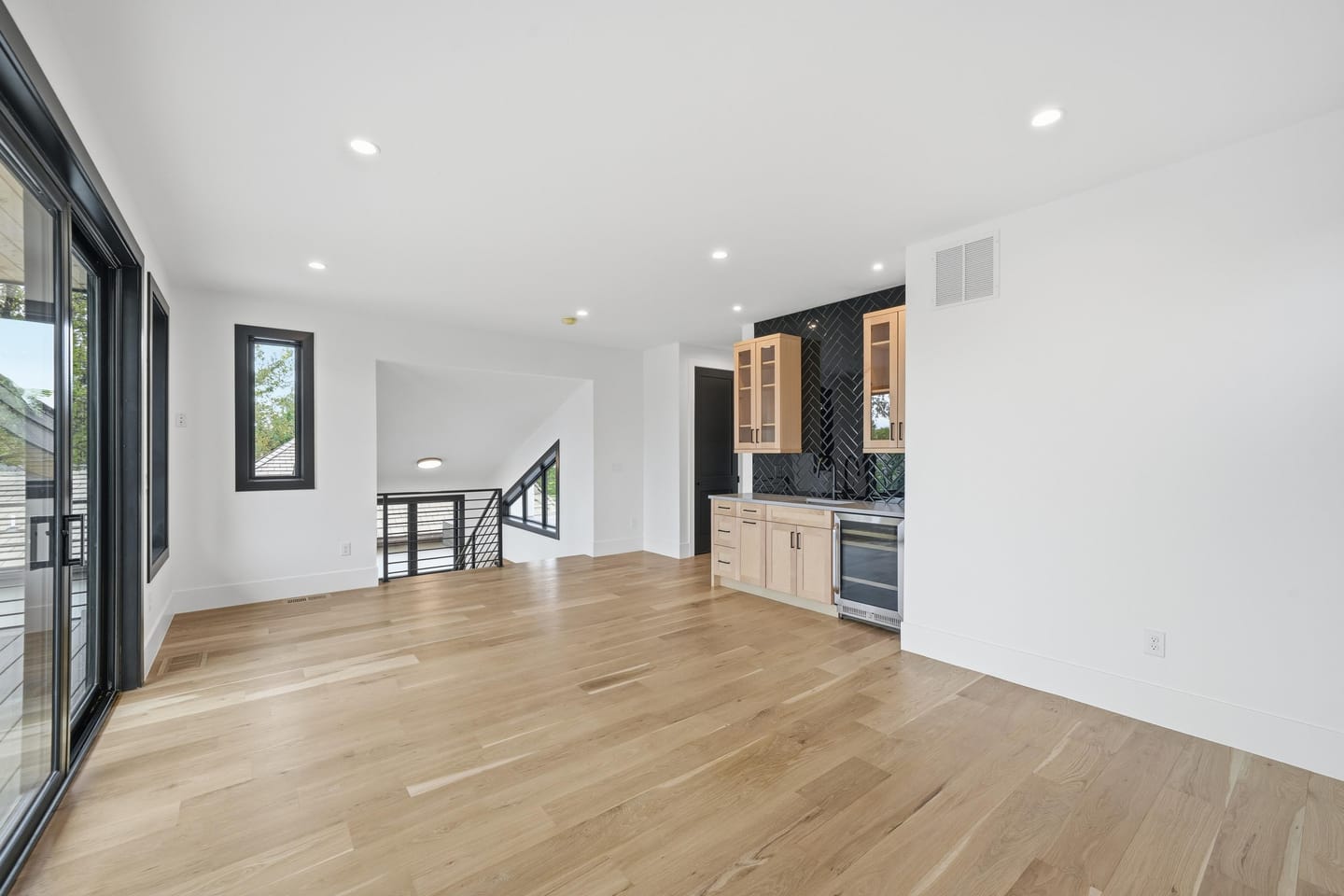 Upper-level lounge with wet bar opening to the rooftop deck