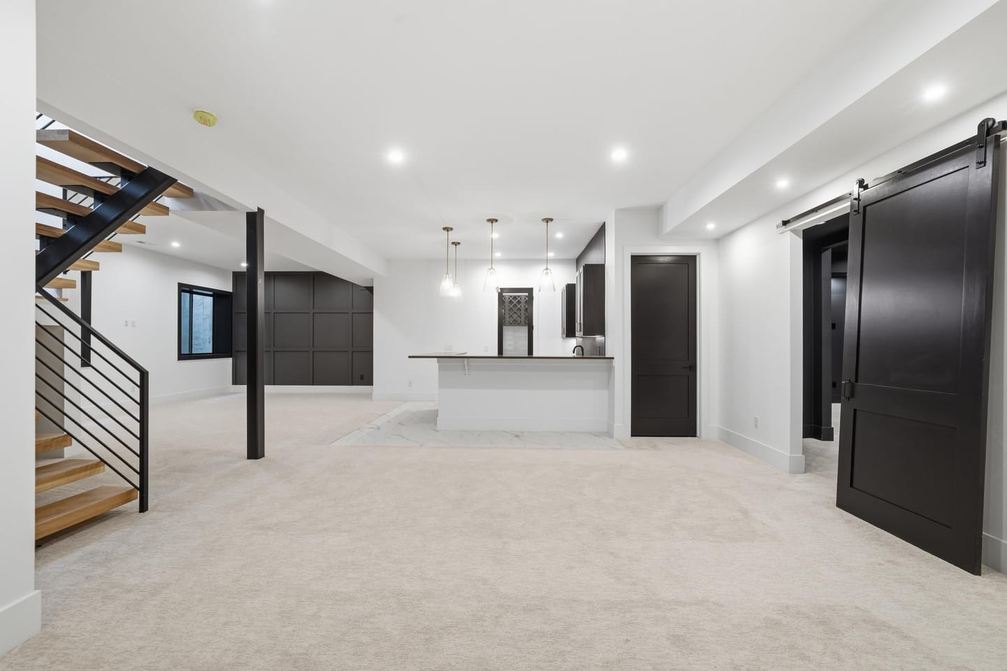 Lower-level recreation room with wet bar and stair