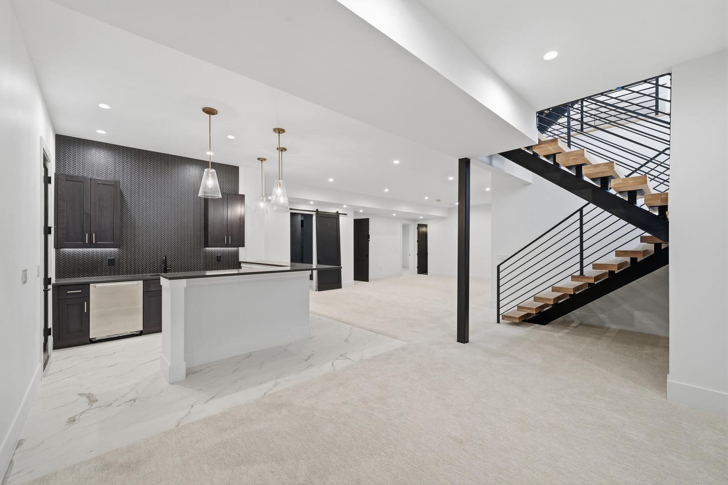 Lower-level recreation room with wet bar and stair