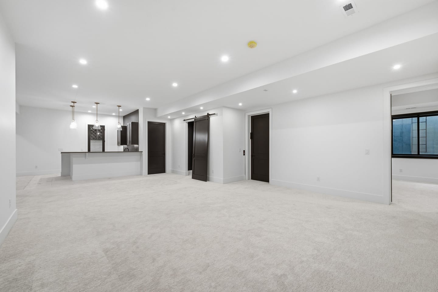 Lower-level recreation room with wet bar and stair