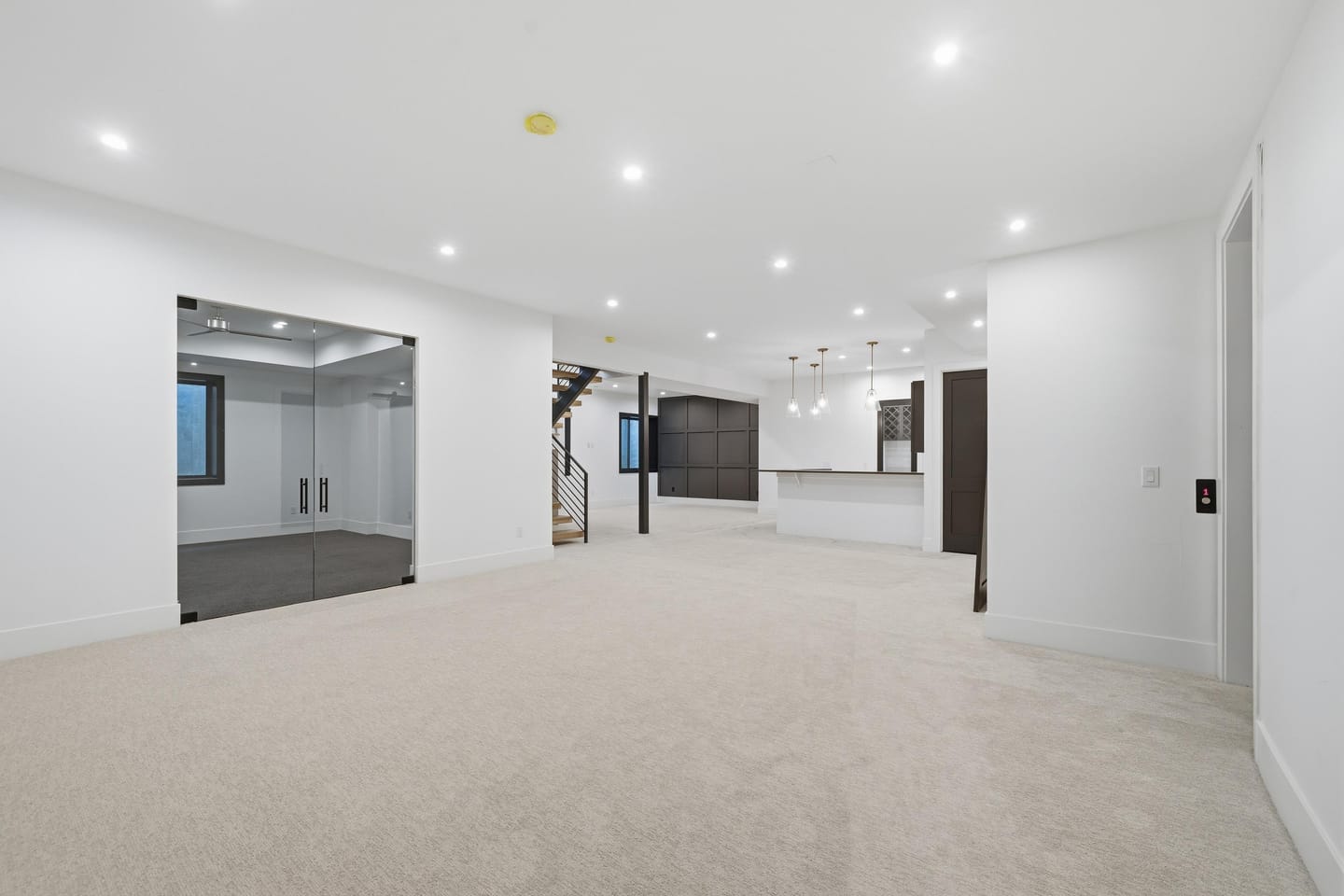 Lower-level recreation room with wet bar and stair