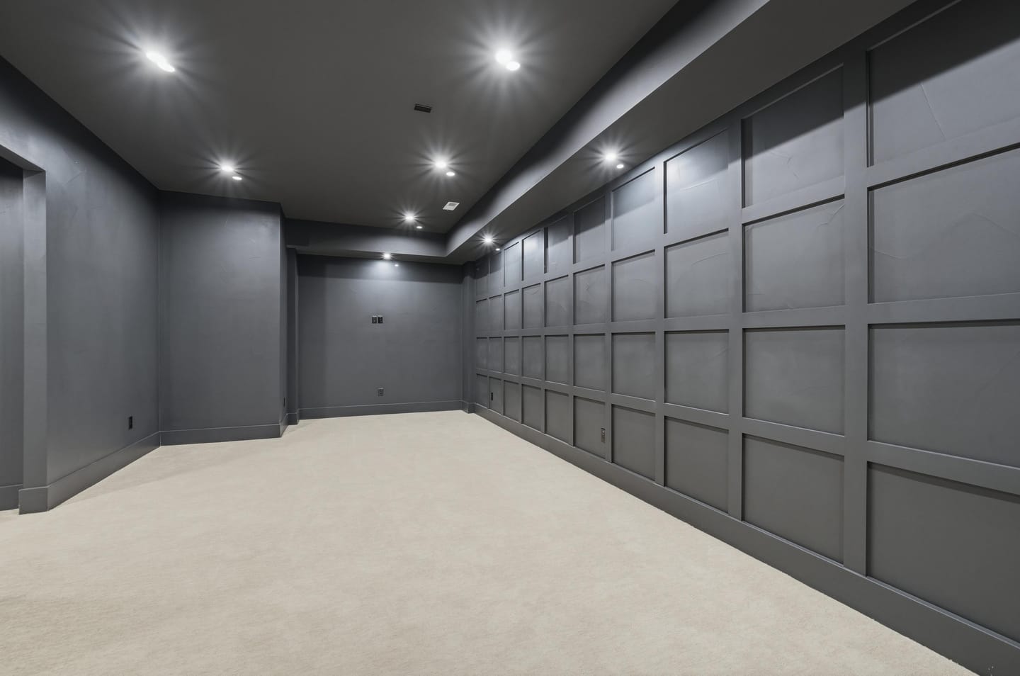 Home theater with charcoal paneled walls and ceiling