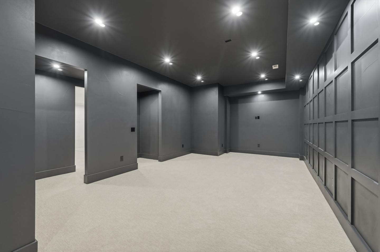Home theater with charcoal paneled walls and ceiling